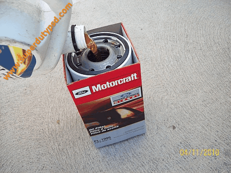 filling new oil filter with oil